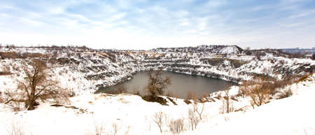 Panorama of flooded granite quarry in winter