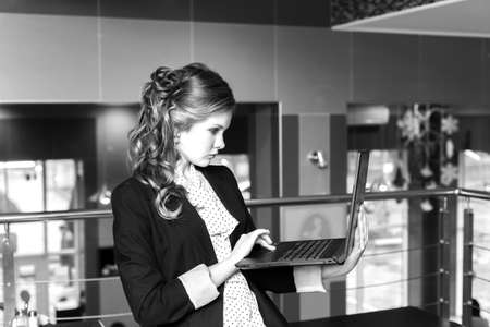 Young beautiful women standing in a cafe and working on laptop. monochromeの写真素材