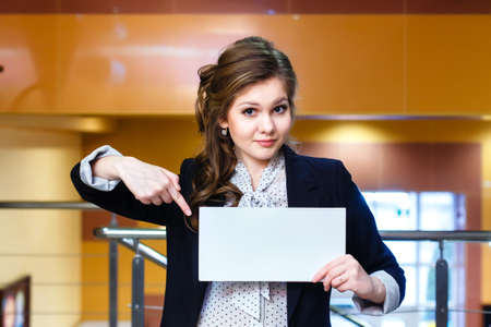 young beautiful girl shows on blank white cardの写真素材