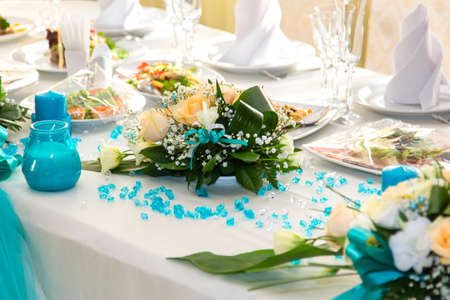 Bouquet of roses and turquoise decoration on the wedding table
