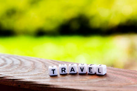 Travel inscription on wooden table on nature backgroundの写真素材