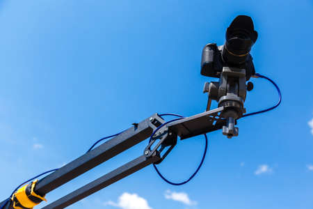 Camera on a crane on a blue sky backgroundの写真素材