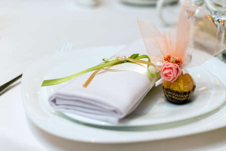 serviette and candy on a plate served on the festive table