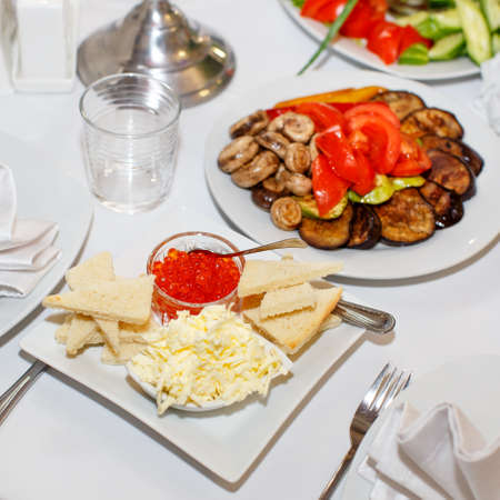 Appetizers with red caviar, pickles on a festive table in restaurantの写真素材