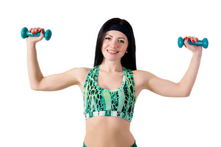 young smiling woman with long brunette hair holding a blue dumbbell. Isolated on white background in...