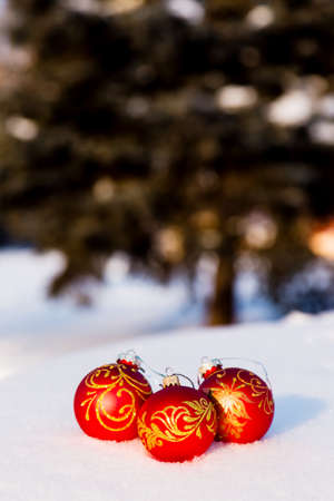 Three red christmas balls on a snow. New Year greeting card concept. Copy-spaceの写真素材