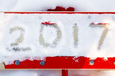 Numbers 2017 in the snow on the red swing for children. Concept for a New Year's greeting cardの写真素材