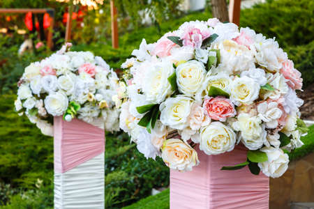 Two beautiful bouquets of roses outdoors. Wedding ceremony decoration.の写真素材