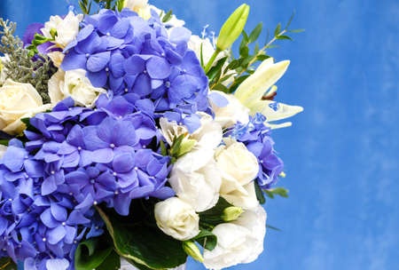 Flowers bouquet of blue hidrangea and white eustomas on blue background.の写真素材