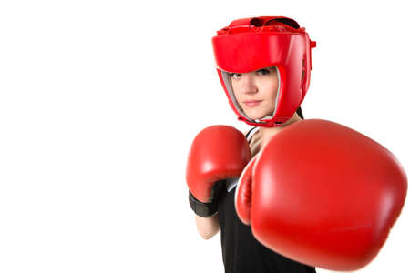 Young brunette woman in red boxing gloves and helmet making impact, looking at camera. Isolated on...