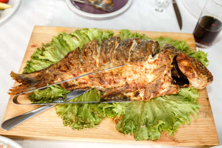 Fried fish close up on a banquet table in a restaurantの写真素材