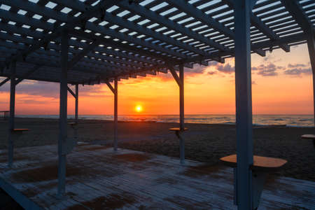 Silhouette of a wooden gazebo at sunset on a deserted beachの写真素材