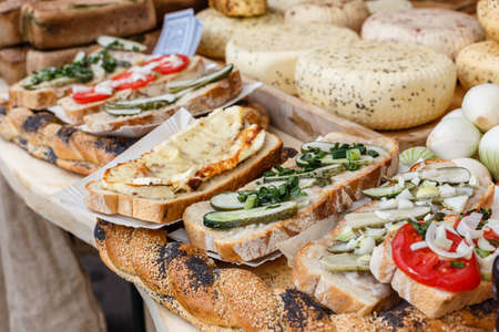 Bread with cheese, cucumbers, tomatoes on a picnic tableの写真素材