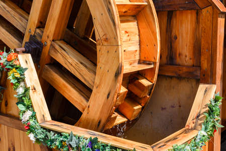 Beautiful wooden water mill decorated with flowers.
