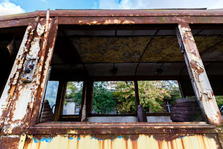 Old rusty wagon of destroyed tram outdoors at sunny day.