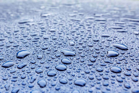 Rain drops close-up on a blue car body with Hydrophobic Effect.の写真素材