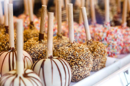 Apples covered with chocolate and various glazes for sale in a shop window. Selling sweets at the...