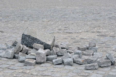 Pile of granite stones on old cobblestone pavement.の写真素材