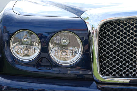 Headlights , radiator and hood of luxury retro vintge blue car ckose-up.
