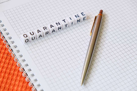 Text Quarantine , word made of cubic letters and luxury pen on a white paper note pad background. Working home at coronavirus pandemia conceptの写真素材