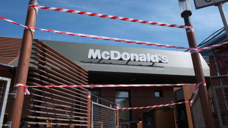 KRYVYI RIH, UKRAINE - APRIL, 2020. McDonald's fast food restaurant building surrounded by red and...
