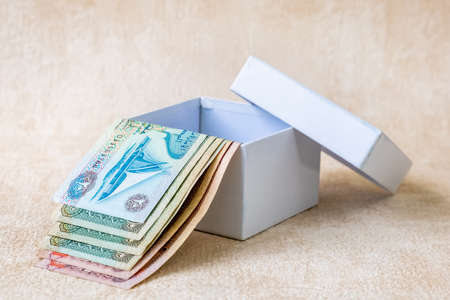 Many UAE Dirham Bank notes, Arabian Money in white gift box. Studio Shot.
