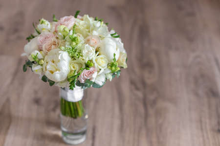 Wedding bouquet in a glass vase on the floor near the wall.の写真素材