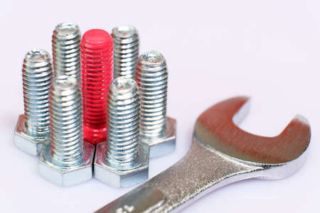 Close-up of pink bolt in a group of galvanized metallic screws and wrench.の写真素材
