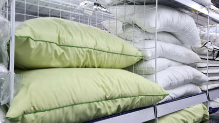 Many beautiful green and white pillows sells on a shelf in the store.の写真素材