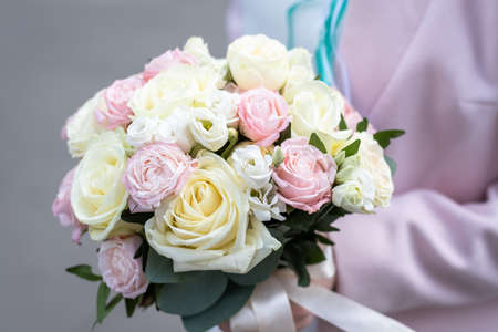 Bride holding bridal bouquet of roses outdoors.の写真素材
