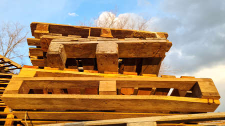 Stack of Old Used Wooden pallets outdoors in the warehouse of cargo delivery enterprise on a cloudy...