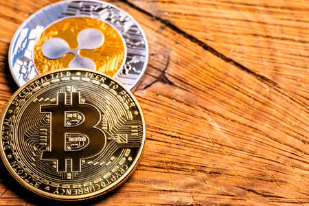 Crypto Coins Bitcoin and Ripple close-up on a wooden table. Copy space, cryptocurrency background.