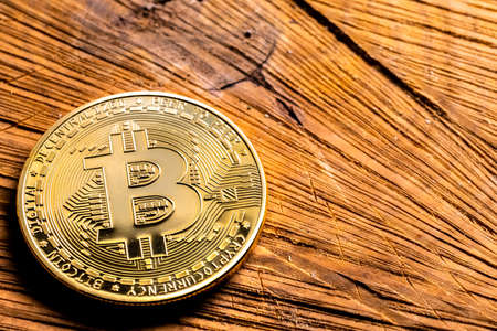 Crypto Coin Bitcoin close-up on a wooden table. Copy space, cryptocurrency background.