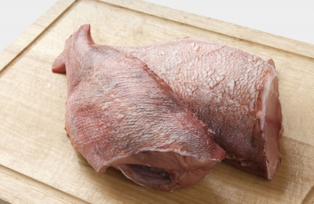 Two raw trunks of rosefish on the wooden boardの写真素材