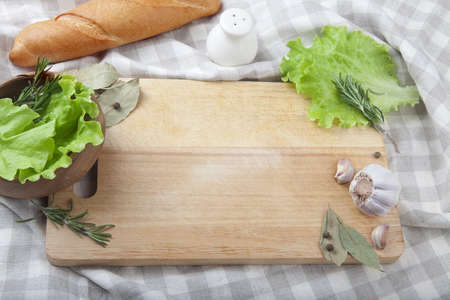 Wood board on the tablecloth with produce aroundの写真素材