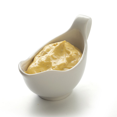 Yellow mustard sauce in the white sauceboatの写真素材