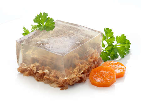 Isolated piece of beef aspic with green fresh parsley and orange carrotの写真素材