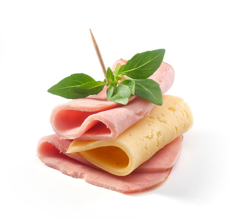 Folded cheese and ham with fresh green basil on the whiteの写真素材