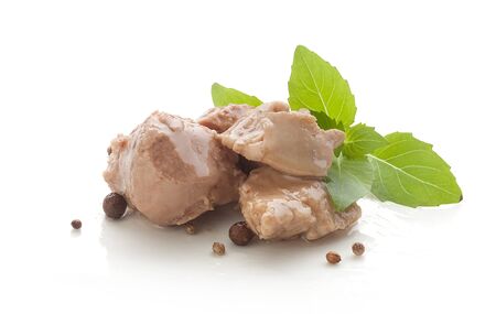 Some pieces of cod liver with fresh green basil on the white plateの写真素材