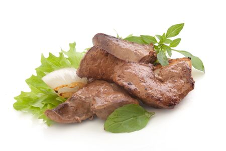 Fried pieces of beef liver with fresh green lettuce, basil and fried onion on the white plateの写真素材