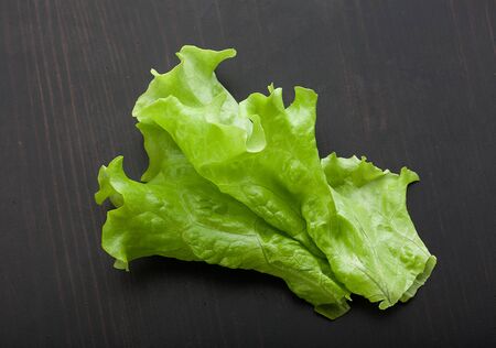 Top view of green fresh lettuce on the black wooden tableの写真素材