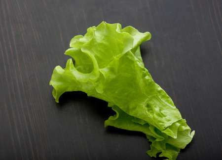 Top view of green fresh lettuce on the black wooden tableの写真素材