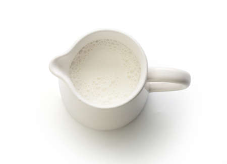 Top view of milk jug with milk on the whiteの写真素材
