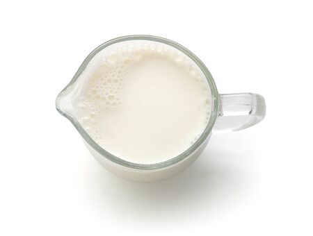 Top view of glass milk jug with milk on the whiteの写真素材