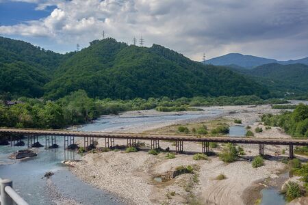 Old road bridge over mountain river Shakheの写真素材