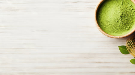 Matcha tea powder in a wooden plate on light wooden background with whisk, top view, copy space. Generative AI.の素材