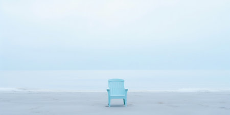 Lonely chair on white sand of tranquil beach of sea covered with mist. Generative AI.の素材