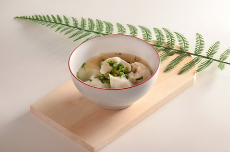 Wonton Soup Fresh Herbs with wooden coaster backgroundの写真素材