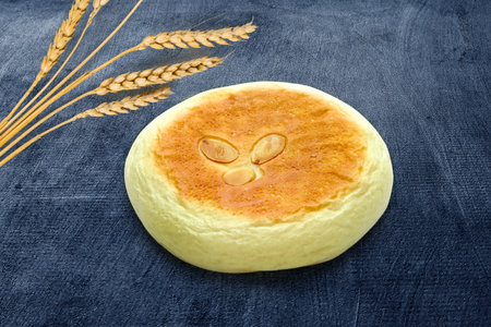 Close-Up of Round Sweet Bread with Almond Topping on Blue Background