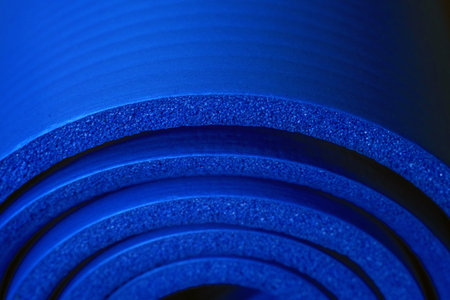 Close-Up of Rolled Blue Foam Yoga Mat with Spiral Layer Designの写真素材